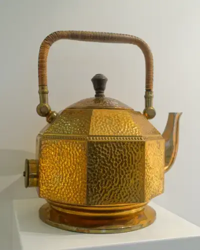 Hervidor eléctrico, diseñado por Behrens para AEG, de latón martillado y mimbre, hacia 1909